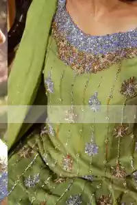 Pistachio green pure crinkle chiffon shirt and dupatta with blue pure raw silk trousers. The shirt has been embroidered with silver and gold embroidery on the neckline and stripes all over the front.
