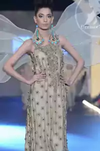 Fawn's dress has been beautifully embellished with a long neckline and a border on the hemline. Sequine fabric lace has been implemented at the bottom of the maxi. Close motif spray all over the dress. Fawn Sides Down Fully Embellished Party Dress.