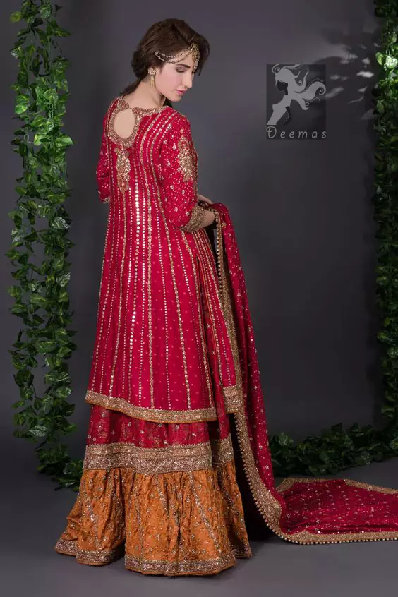 Crimson A-line slits shirt adorned with beautiful neckline, stripes and hemline. Matching dupatta having embellished border on four sides, sequence and small motifs spray all over it. Lehenga in Crimson and Copper having embellished Gott like gharara (below the knee), stripes and small motifs spray. Embellishment in light and dark antique shades.