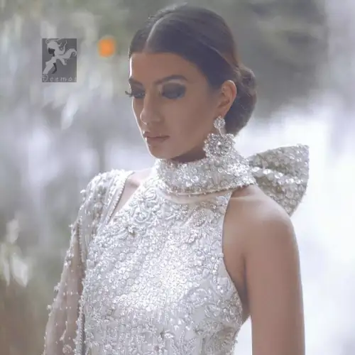 White choli / blouse having beautiful embellishment in white, silver and maroon brown. Halterneck design has been implemented on blouse