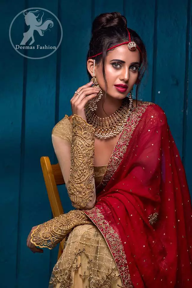 This outfit has antique brass pure banarsi jamawar blouse and embroidered net full sleeves. It comes with lehengha which embodies criss cross pattern all over it. It is further enhanced with floral borders around daman. Lehengha is scalloped and highlighted with tilla and silk thread embroidery (Resham). It is embellished with dull golden, antique shaded kora, dabka, tilla and sequins. This outfit is beautifully coordinated with scarlet embellished dupatta, decorated with four sided floral embroidery and spray of different sizes floral motifs and sequins all over it.