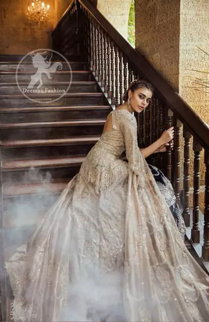 An ivory front open tissue shirt with heavy embroidery decorated with dull golden and champagne kora, dabka, tilla, naqshi, sequins and swarovski. It is further allured with cutwork and floral embroidery. Its umbrella sleeves is embellished with delicate zari work. Its black inner shirt is also embroidered. This outfit is artistically coordinated with black chiffon sharara which is allured with floral embroidery. This outfit is fully scalloped and enhanced by a thick floral embellished pattern. Dress comes with ivory dupatta which has finished edges and having sprinkled sequins pattern all over it.