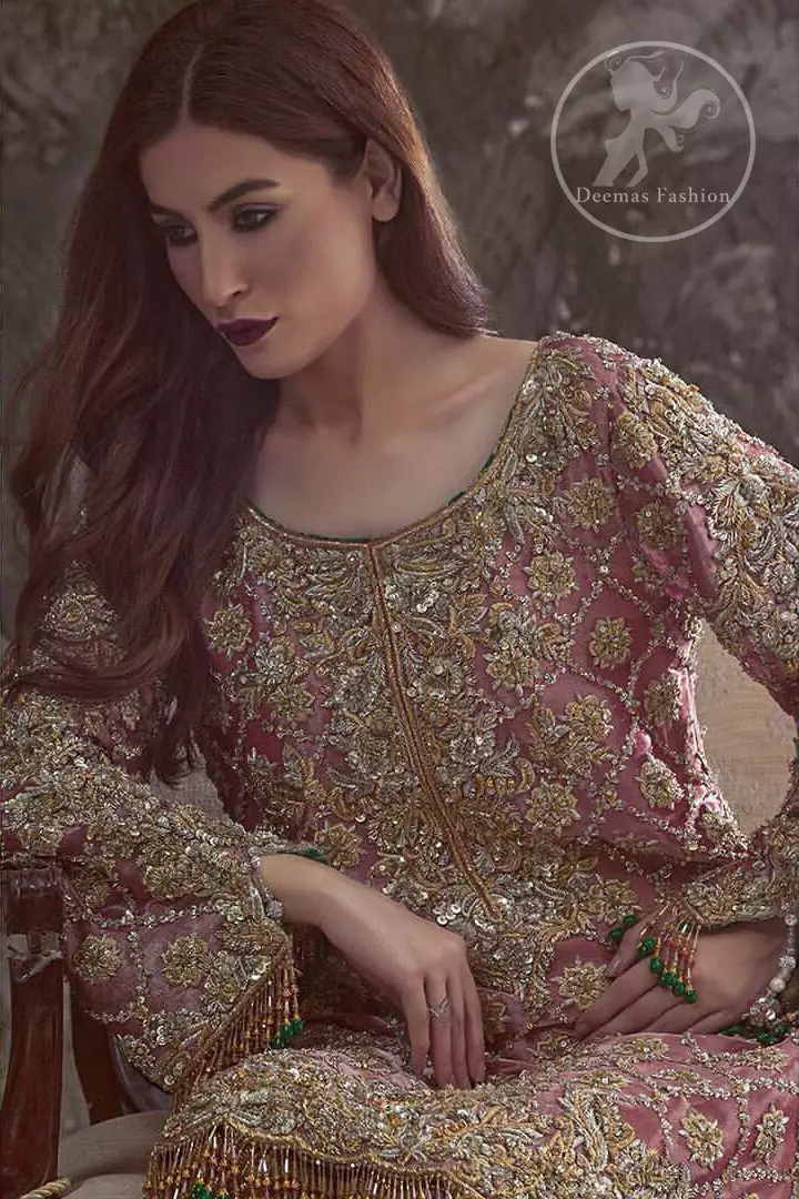 This outfit is beautifully sculptured with floral embroidery. It is adorned with criss cross design. This shirt is meticulously highlighted with dull golden and antique shaded kora, dabka, tilla, sequins and pearls. It is decorated with tassels which adds to the look. It comes with brocade pajama decorated with floral motifs. It is coordinated with chiffon dupatta adorned with sprinkled sequins all over it.
