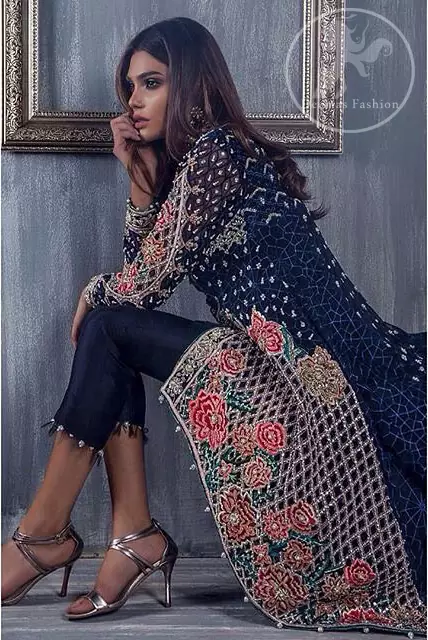 This classic bluish front open back trail meticulously highlighted with dull golden kora, dabka ,tilla, sequins and pearls. It is fully embroidered shirt decorated with intricate cutwork. It is adorned with V-Shaped neckline. This shirt is decorated with small and large sized floral motifs. It comes with silk pajama/sharara and beautifully decorated with chiffon dupatta having sprinkled sequins all over it.
