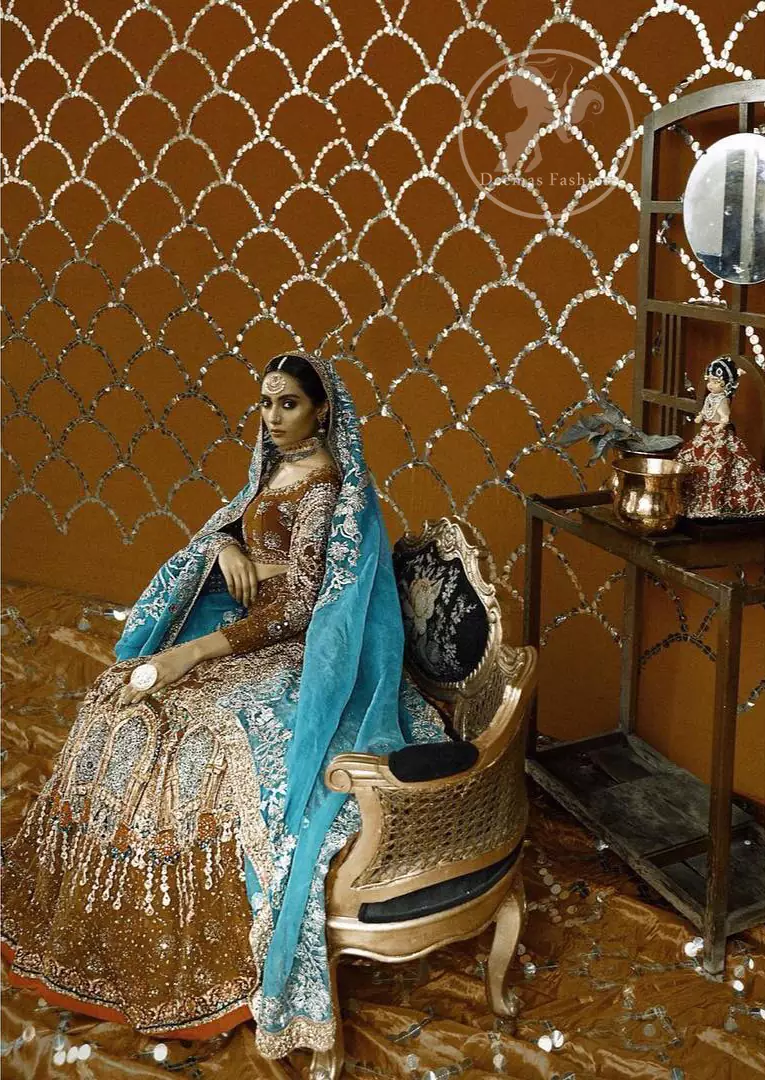 This outfit is meticulously highlighted with different shaded kora, dabka, tilla, sequins and swarovsky with silver touch. This dress is beautifully sculptured with floral embroidery. The sleeves are beautifully embellished with Victorian style frame. It is artistically coordinated with embellished surfie green dupatta which has four sided appliqued border. It comes with brown bramble lehengha which has heavy upper front appliquéd border.
