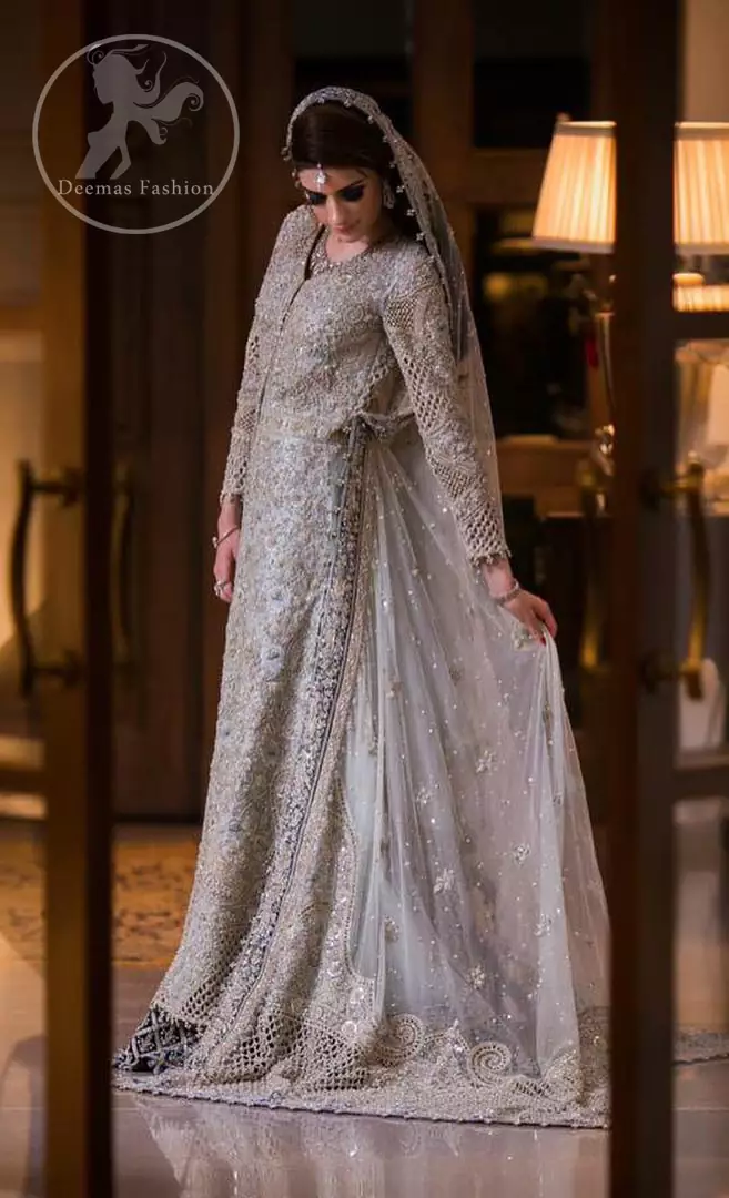 This outfit is beautifully sculptured with floral embroidery. It is adorned with intricate cutwork borders embellished with silver kora, dabka, pearls and sequins work all over. Inner is embellished with blue embroidered border. It is artistically coordinated with heavy embellished chiffon/net dupatta with blue appliqued border on sides. It comes with light gray brocade churidar pajama.

