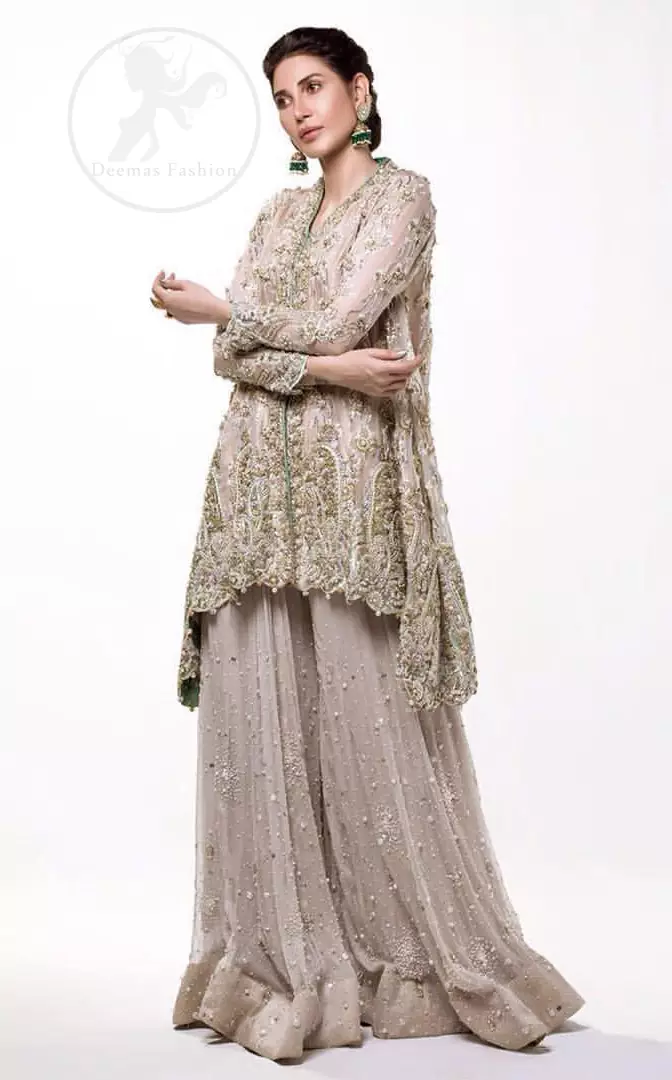 This sides down short frock is decorated with kora, dabka, tilla, sequins and pearls. It is embellished with floral embroidery. It is further enhanced with embroidered scalloped border which adds to the look. It comes with sharara which is adorned with floral motifs all over it. It is beautifully coordinated with chiffon dupatta which is sprinkled with sequins all over.

