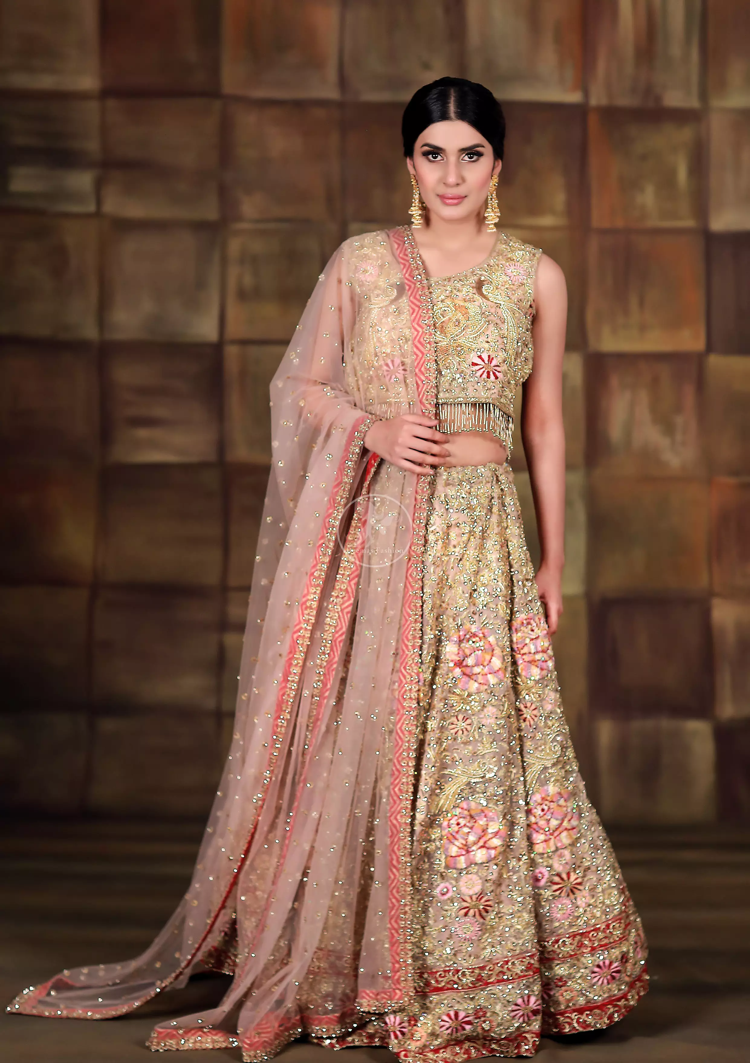 This dress is beautifully sculptured with floral thread embroidery. Blouse is fully embellished and decorated with tassels. Lehengha is embellished with different shaded thread embroidery, allured with kora, dabka, tilla, sequins and pearls. It comes with net dupatta which has four sided embroidered border and sprinkled with pearls and sequins all over it.