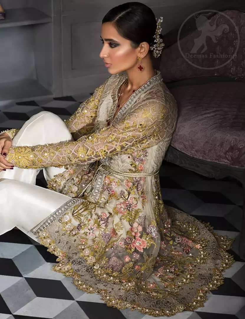 This open short frock is decorated with resham thread, kora, dabka, tilla, sequins and pearls. It is self embroidered shirt embellished with floral thread embroidery. it is further enhanced with embroidered scalloped border which adds to the look. It comes with pants. It is beautifully coordinated with chiffon dupatta which is sprinkled with sequins all over.
