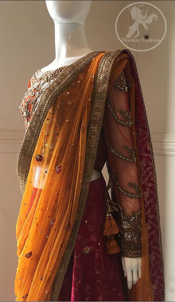 This dress is beautifully sculptured with floral embroidery. It is adorned with intricate detailing embellishment with antique gold kora dabka, tilla, kundan and swarovski. The blouse has full length sleeves decorated with floral motifs. It is coordinated with hot pink banarsi lenhengha finished with golden gota lace at the bottom. It is enhanced with floral motifs. The outfit is beautifully coordinated with orange pallu style dupatta embellished with golden Gotta lace on all sides.