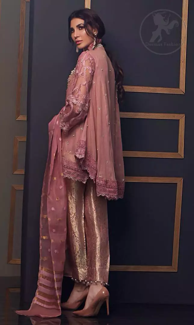 This outstanding angrakha style shirt meticulously highlighted with dull golden and antique shaded kora, dabka , tilla, sequins and pearls. This dress is beautifully adorned with floral embroidery. Sleeves are decorated with resham embroidery which adds to the look. It comes with brocade pajama. It is beautifully coordinated with chiffon dupatta having sprinkled sequins all over it.