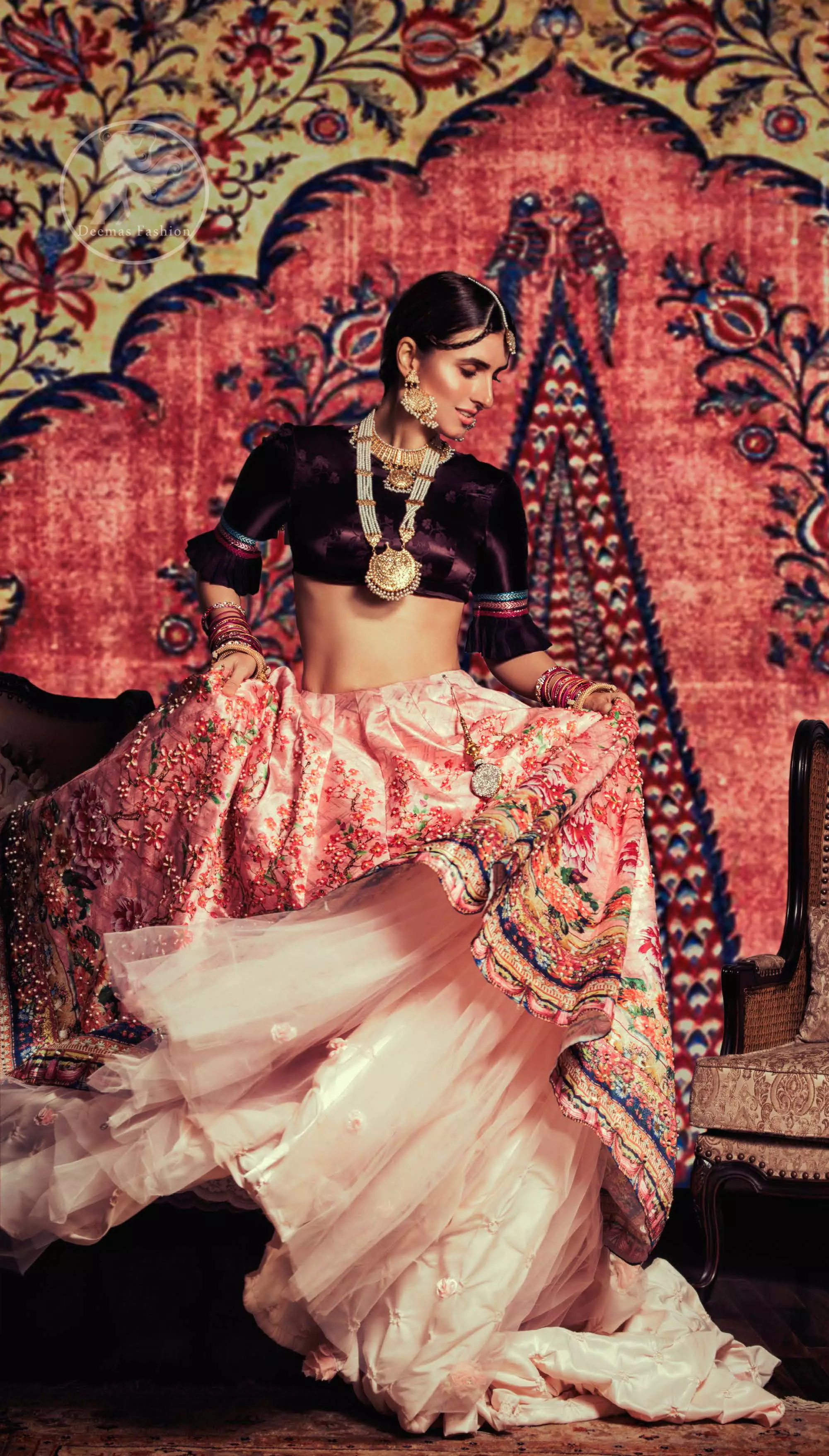 This outfit is a timeless beauty. Dark purple self-printed blouse is decorated with applique. The raw silk classic lehenga is adorned with digital print. Its floral print is further decorated with swarovski, tilla, kora dabka . Its beautiful printed border adds to the look. This outfit is beautifully coordinated with peach pink dupatta with heavy embroidered borders.