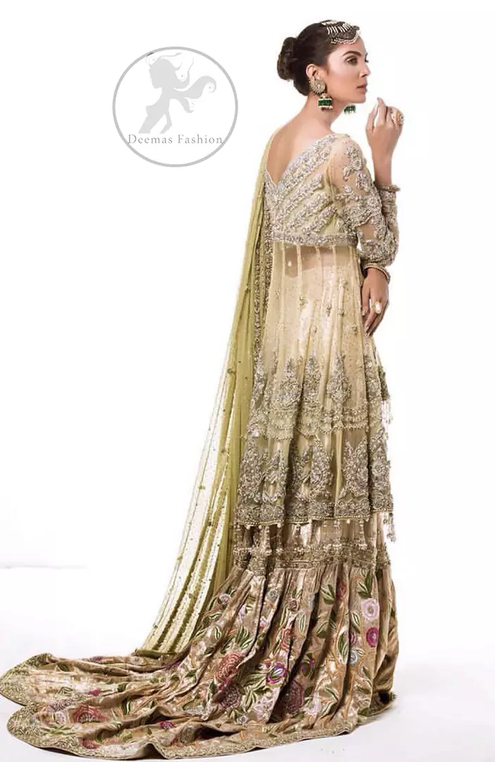 This dress is beautifully sculptured with floral embroidery. It is meticulously highlighted with antique shaded kora, dabka, tilla, sequins and pearls. It is embellished with beautiful tassels which adds to the look. It is artistically paired up with gharara which comprises of floral thread colourful motifs. It comes with chiffon dupatta which has four sided embellished borders and sprinkled with small sized sequins motifs all over it.