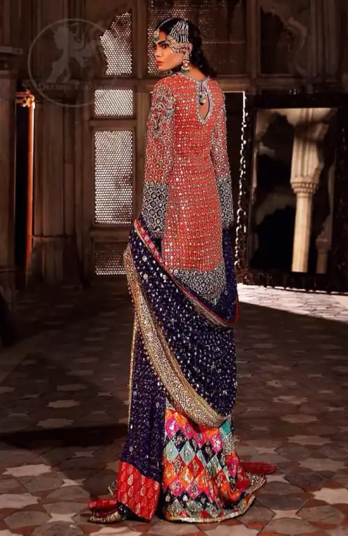 This unique bridal dress is beautifully sculptured with floral thread embroidery. It is meticulously highlighted with silver and antique kora