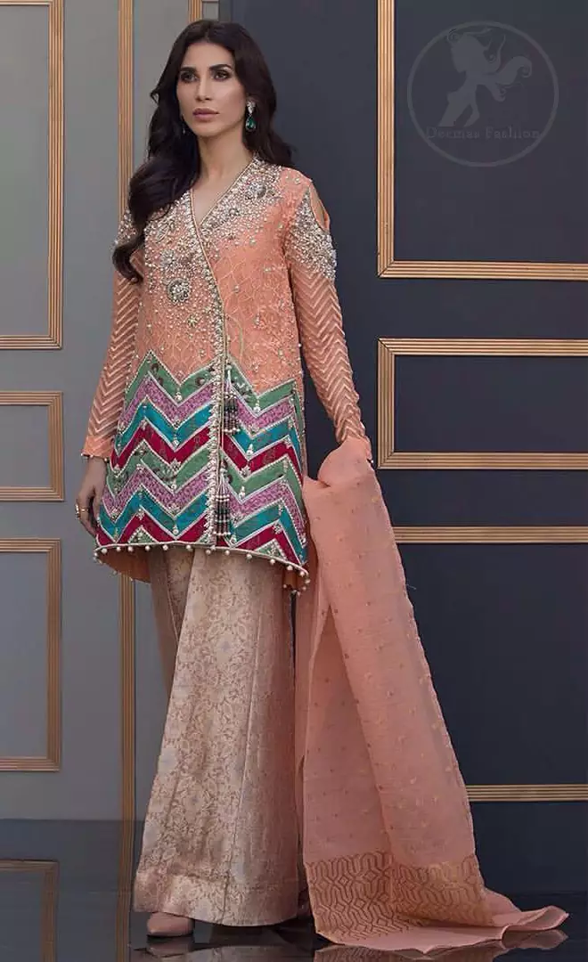This beautiful self embroidered angrakha embellished with floral thread embroidery. This shirt is decorated with kora, tilla, dabka, swarovsky and sequins. It is allured with cold shoulder sleeves. Daaman of the shirt is decorated with different colour zik zak brocade applique which adds to the look. It is beautifully paired up with brocade trousers.It comes with organza dupatta.