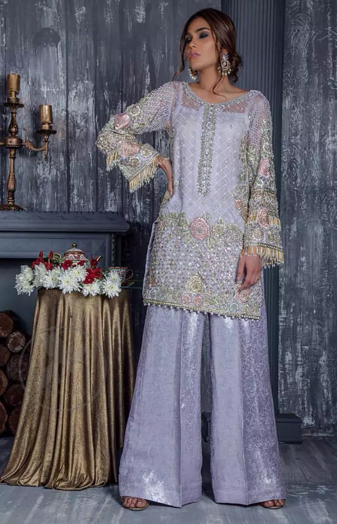 Standout in this gorgeous chiffon shirt embellished with tilla, kora dabka, sequins and pearls.It is further enhanced with floral thread embroidery.Its hemline and sleeves are beautifully decorated with golden tassels.It is beautifully coordinated with self print jacquard trousers. It comes out with chiffon dupatta decorated with sequins spray all over .