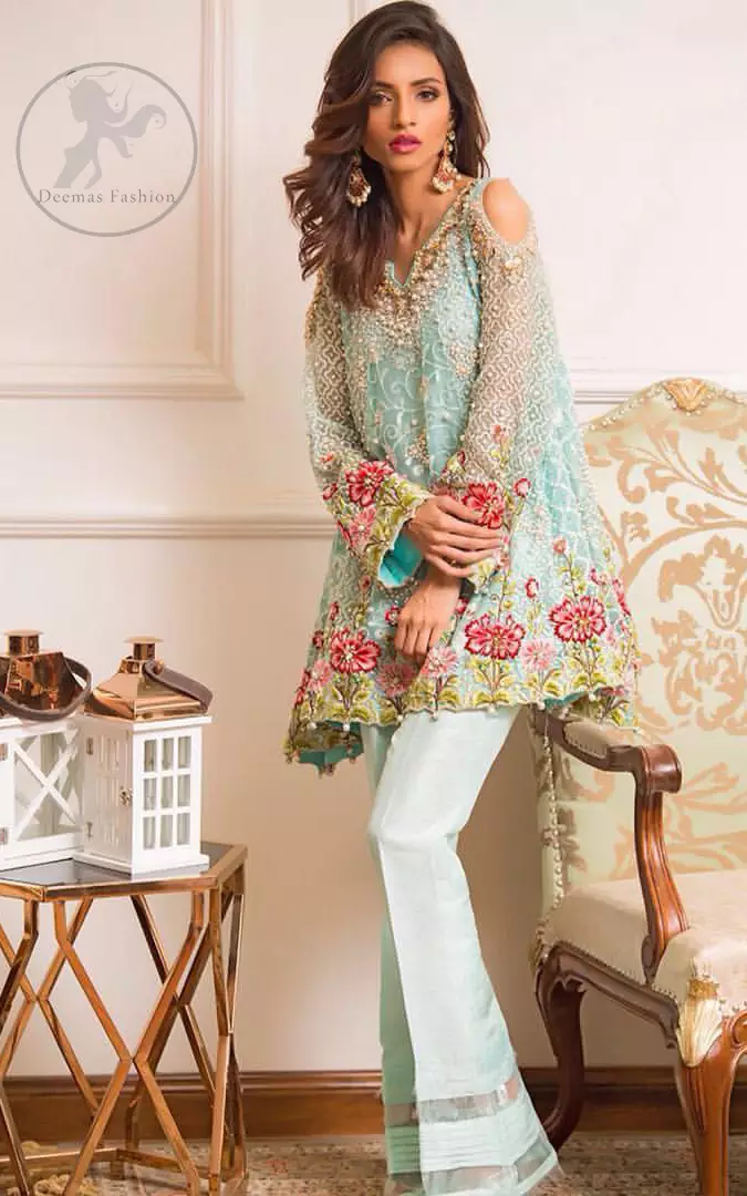 This outstanding self embroidered short frock embellished with floral thread embroidery. It is allured with resham kora dabka tilla and pearls. Sleeves are decorated with cold shoulders design and floral embroidery. Scalloped hemline ornamented with tassels. It is beautifully paired up with matching bell bottom trouser. It comes with light blue dupatta sprinkled with sequins all over it.
