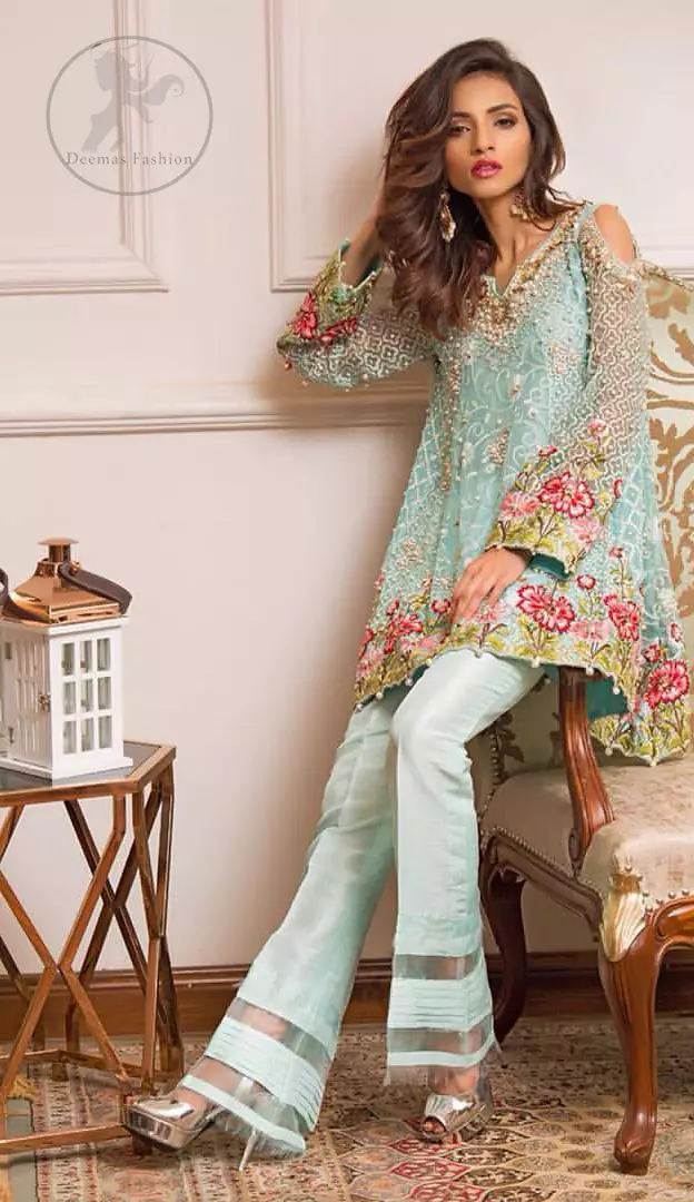 This outstanding self embroidered short frock embellished with floral thread embroidery. It is allured with resham kora dabka tilla and pearls. Sleeves are decorated with cold shoulders design and floral embroidery. Scalloped hemline ornamented with tassels. It is beautifully paired up with matching bell bottom trouser. It comes with light blue dupatta sprinkled with sequins all over it.