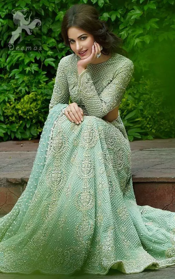 This dress is beautifully sculptured with floral embroidery.It is meticulously highlighted with dull golden and silver shaded kora, dabka, tilla, sequins and pearls. Full sleeves blouse is allured with embroidery. Waistline is adorned with swarovsky. It comes with net dupatta having sprinkled sequins all over it. It is coordinated with fully embellished lehengha.