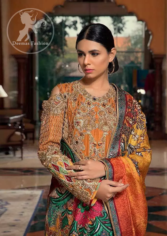 A jaffa color shirt heavily embellished in the front with antique shaded kora dabka, kundan, tilla, sequins and pearls. Floral motifs on the shirt and cold shoulder sleeves enhance the beauty of this shirt. It is finished with scalloped embellishment border. This dress is coordinated with embroidered cigarette pants and self-printed dupatta.