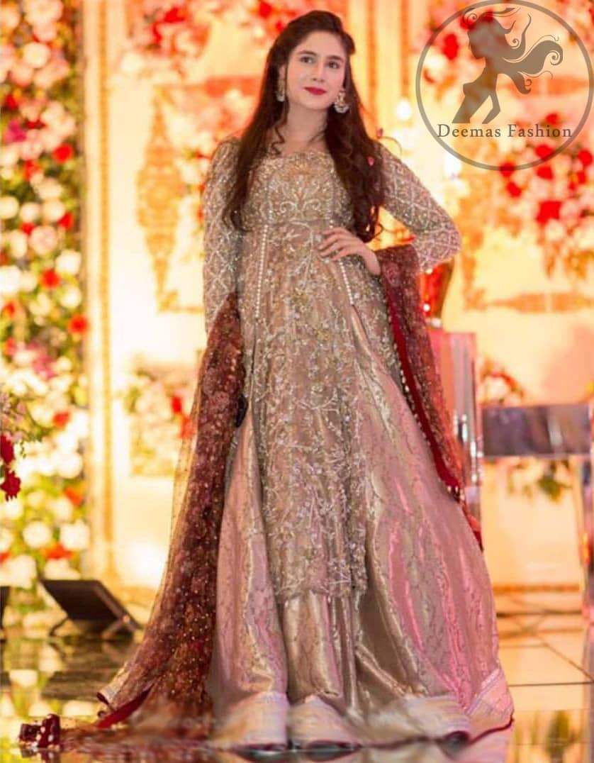 This dress is beautifully decorated with floral embroidery. This exquisite A-line front open shirt is fully decorated with floral and different motifs pattern all over it. It is highlighted with kora, dabka, tilla, sequins and pearls. Front open shirt allured with embellishments. It comes with net sharara. It is coordinated with net dupatta which is allured with delicate tassels.