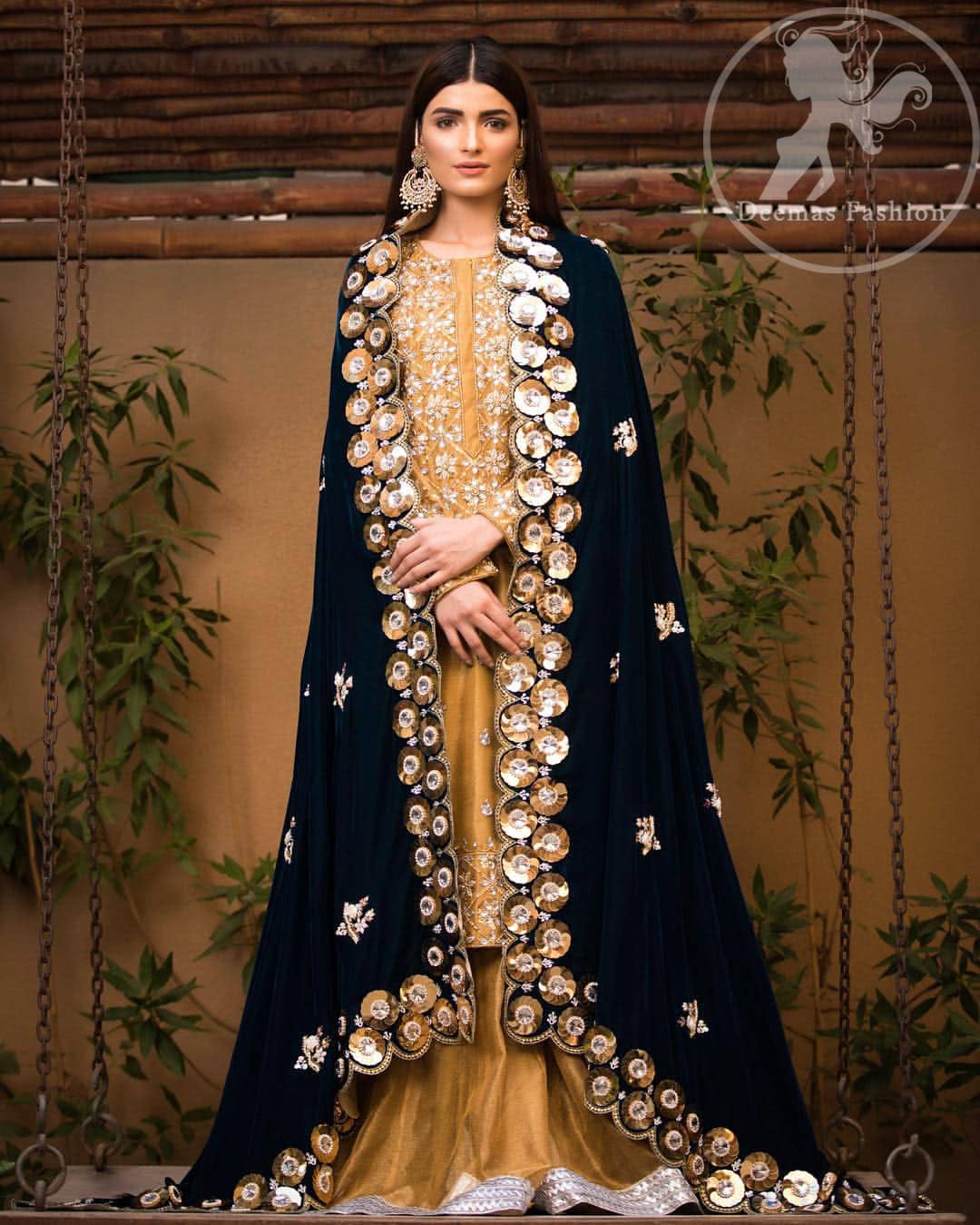 This dress is allured with floral embroidery. It is further enhanced with gota, kundan, sequins and pearls. It comes with organza sharara. It is artistically coordinated with velvet shawl which is adorned with small floral motifs, also having four sided embellished scalloped border.