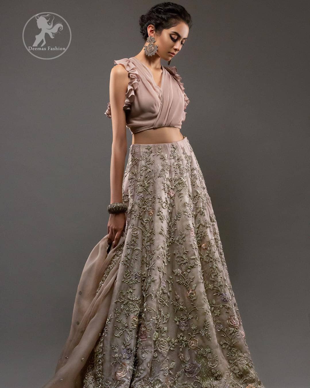 Commemorating the juxtaposition of traditions and modern sensibility with sensuous silhouettes and a subtle pastel palette. Feel glamorous in this stylish blouse paired up with rodeo dust lehengha. The lehengha is delicately crafted with golden kora dabka, tilla and kundan work. Multiple colored floral motifs enhanced the beauty of this outfit. It is coordinated with scalloped embellished border dupatta, also having sprinkled sequins on the ground.