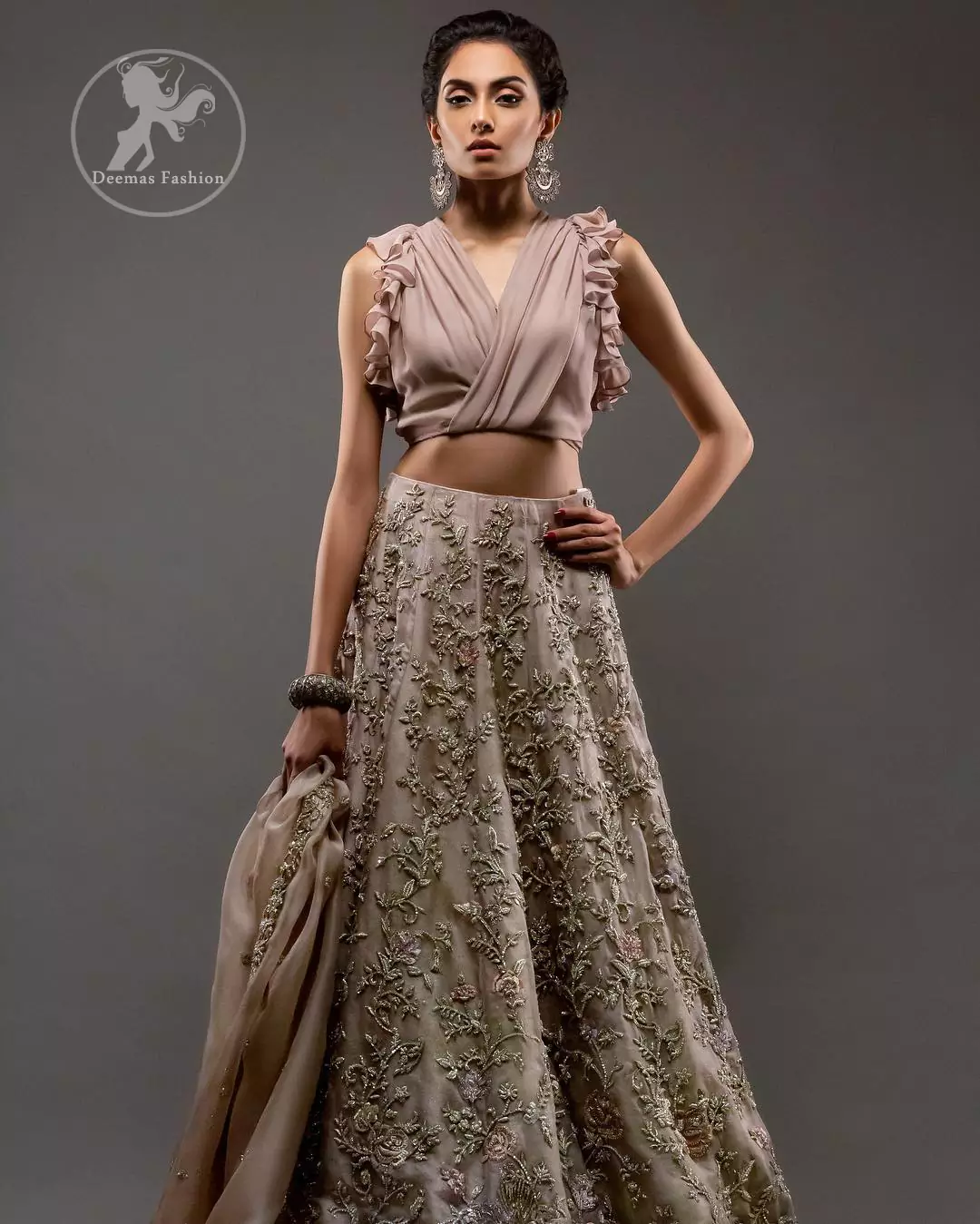 Commemorating the juxtaposition of traditions and modern sensibility with sensuous silhouettes and a subtle pastel palette. Feel glamorous in this stylish blouse paired up with rodeo dust lehengha. The lehengha is delicately crafted with golden kora dabka, tilla and kundan work. Multiple colored floral motifs enhanced the beauty of this outfit. It is coordinated with scalloped embellished border dupatta, also having sprinkled sequins on the ground.