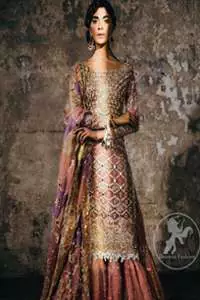 This bridal dress stands out due to its uniqueness and the perfect fusion of modern cut and traditional embroidery. It is enhanced with kora, dabka, tilla, gota, sequins and pearls. Shirt is fully embellished in crisscross pattern. It is artistically coordinated with tissue gharara which is adorned with colourful motifs and
colourful embroidered dupatta detailed with gold gota work and finishing adds to the look.
