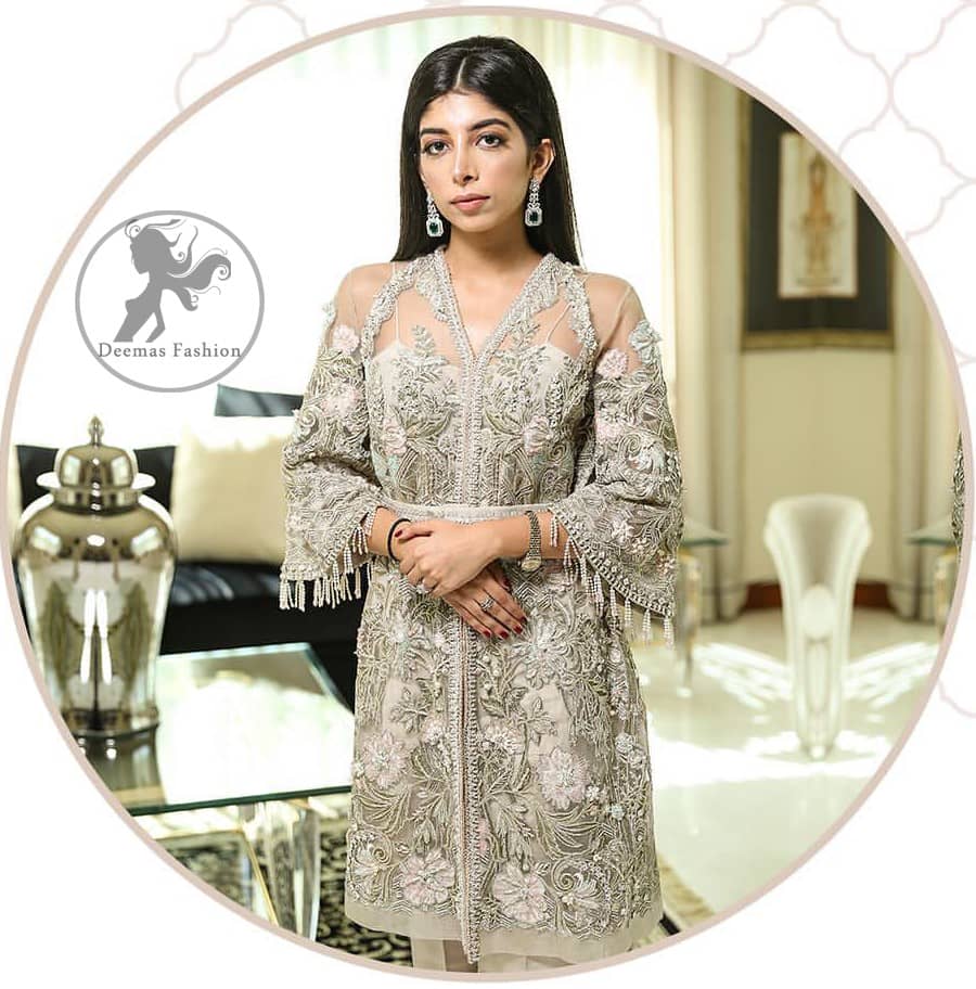 Create a vision of elegance with this front open shirt decorated with intricate floral embroidery detailing and silver kora, dabka and sequins. It is further enhanced with embellished fixed waist belt. Third quarter bell sleeves are adorned with floral embroidery and zardosi work, finishing with tassels at the end. This outfit paired up with raw silk bell bottom. It is coordinated with tissue dupatta which is sprinkled with sequins all over it.