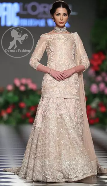 The bridal stands out due to its uniqueness and the perfect fusion of modern cut and traditional embroidery. This dress is beautifully decorated with heavy embroidery. It is highlighted with kora, dabka, tilla, sequins and pearls. It comes with embroidered sharara. It is coordinated with tissue dupatta which is sprinkled with sequins all over it. It is further furnished with four sided scalloped border.
