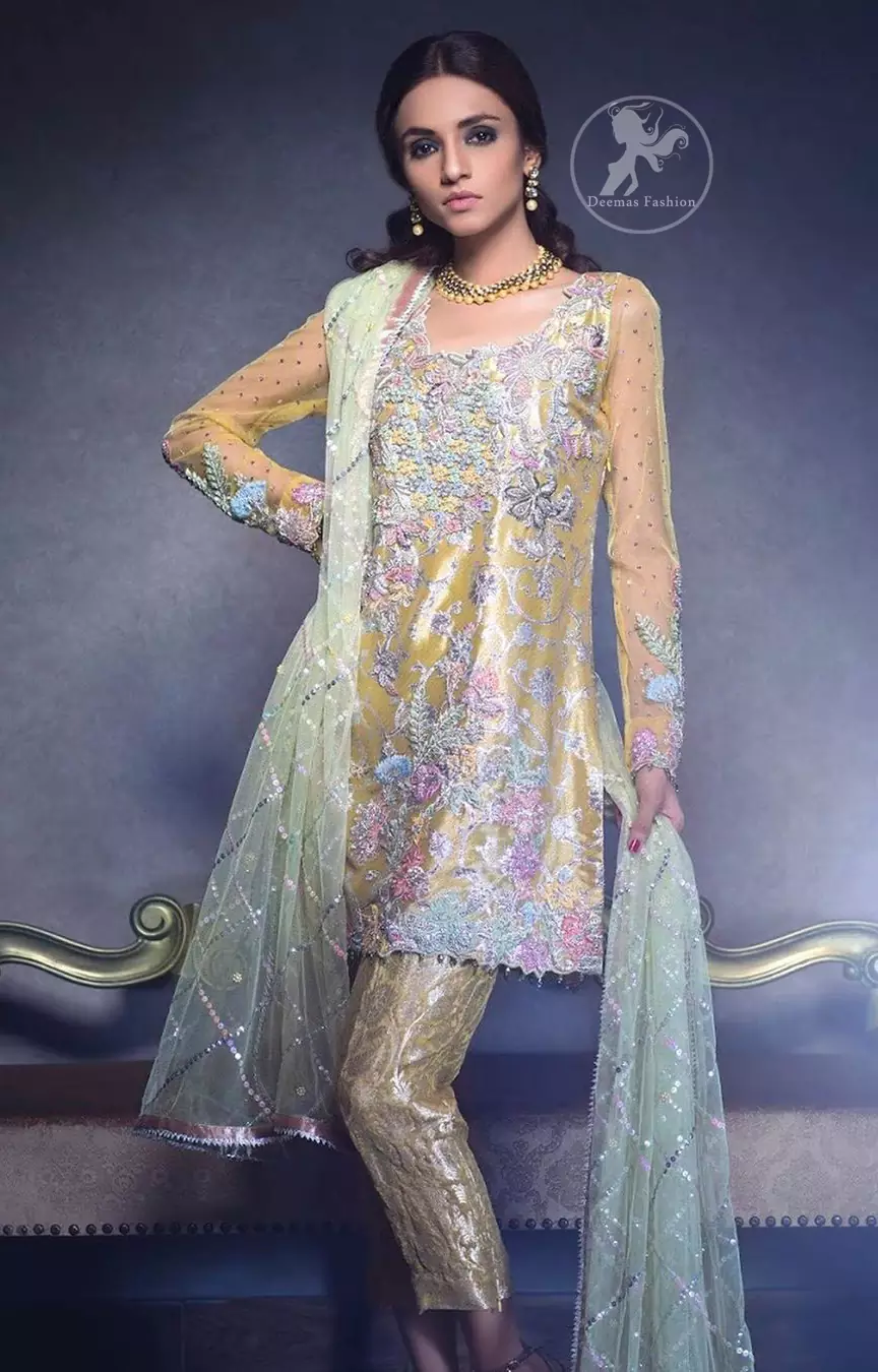 This dress is beautifully decorated with heavy embroidery. It is highlighted with dull golden kora, dabka, tilla, sequins and pearls. Fish lehengha is fully embellished.Blouse is scalloped. It comes with beautifull upper gown, sprinkled with sequins all over it. It is coordinated with chiffon dupatta which is sprinkled with sequins all over it.
