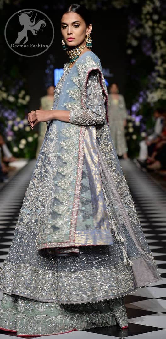 Boost your confidence and style in this glamorous attire accentuated with finest zardosi work embroidery and cut work neckline. It is beautifully decorated with heavy embroidery. It is highlighted with silver kora, dabka, tilla, sequins and pearls. It comes with heavily embroidered lehenga which is decorated with red piping from the bottom. It is coordinated with tissue dupatta which is sprinkled with sequins all over it. It is further furnished with four sided embellished border.