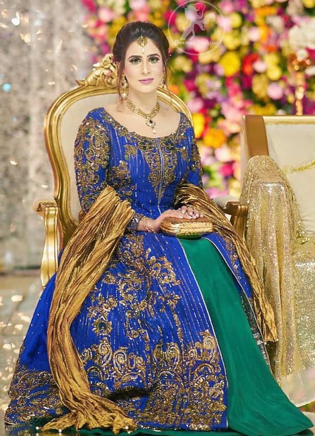This dress is beautifully decorated with heavy embroidery. It is highlighted with dull golden kora, dabka, tilla, sequins and pearls. Fish lehengha is fully embellished.Blouse is scalloped. It comes with beautifull upper gown, sprinkled with sequins all over it. It is coordinated with chiffon dupatta which is sprinkled with sequins all over it.