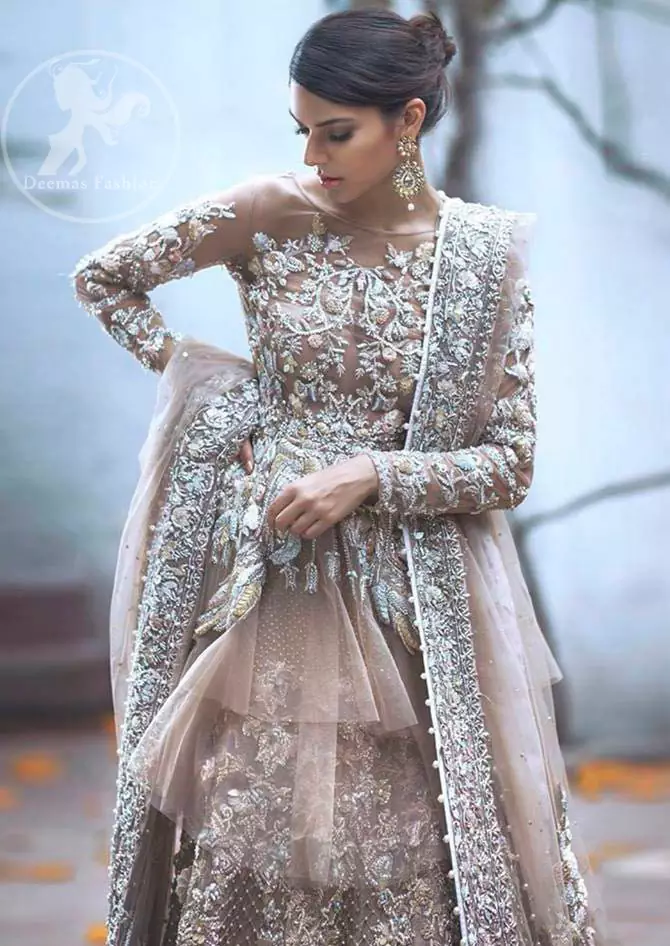 Bring out your beauty with this traditional yet modern zardosi embroidered frilled frock decorated with embellished floral motif and swarovski. It has full length floral embroidered sleeves. This outfit comes with heavy embellished lehenga which is enhanced with silver kora, dabka work and sprinkled sequins all over it. It is coordinated with beautiful dupatta with thick matha patti border on the front and intricate beautiful border on all rest of the three sides.