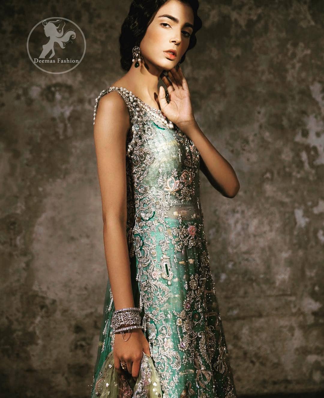 Delicately crafted and personifying chic elegance with an element of grandiose. Heavily embellished in the front with intricate embroidered pattern done with golden and silver kora, dabka, kundan, tilla and sequins. It is further decorated with scalloped boder which having tassels to complete the look. The back of the shirt is embellished with different types of motifs. It comes with matching sharara sprinkled small motifs all over. It is coordinated with olive green chiffon dupatta which is sprinkled with sequins all over it.