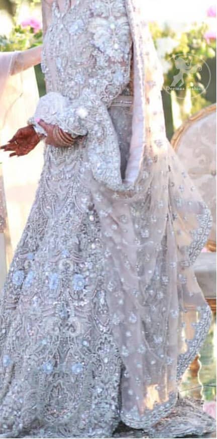 The grand gold bridal stands out due to its uniqueness and the perfect fusion of modern cut and traditional embroidery. This dress is beautifully decorated with heavy embroidery. It is highlighted with kora, dabka, tilla, sequins and pearls. Style it up with embellished wait belt. It comes with brocade pajama. It is coordinated with tissue dupatta which is sprinkled with sequins all over it. It is further furnished with four sided thick embellished border.