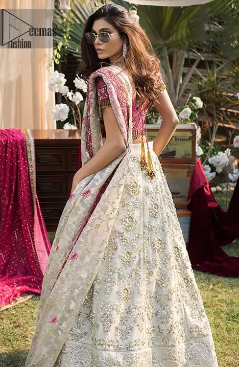 This dress id perfect for Reception or Nikah day. The bridal stands out due to its uniqueness and the perfect fusion of modern cut and traditional embroidery. Make your big day more interesting with this shabby chic statement intensified with rich zardosi work all over the front and bold patterns at daaman. The blouse is fully embellished with champagne and antique shaded embroidery all over and finishing with tassels. The outfit is beautifully coordinated with self printed dupatta adorned with shocking pink embellished applique on all four sides.