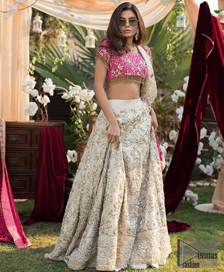 This dress id perfect for Reception or Nikah day. The bridal stands out due to its uniqueness and the perfect fusion of modern cut and traditional embroidery. Make your big day more interesting with this shabby chic statement intensified with rich zardosi work all over the front and bold patterns at daaman. The blouse is fully embellished with champagne and antique shaded embroidery all over and finishing with tassels. The outfit is beautifully coordinated with self printed dupatta adorned with shocking pink embellished applique on all four sides.
