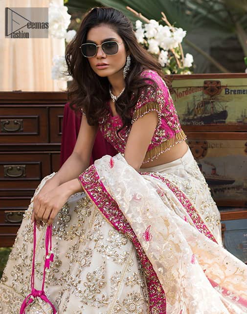This dress id perfect for Reception or Nikah day. The bridal stands out due to its uniqueness and the perfect fusion of modern cut and traditional embroidery. Make your big day more interesting with this shabby chic statement intensified with rich zardosi work all over the front and bold patterns at daaman. The blouse is fully embellished with champagne and antique shaded embroidery all over and finishing with tassels. The outfit is beautifully coordinated with self printed dupatta adorned with shocking pink embellished applique on all four sides.