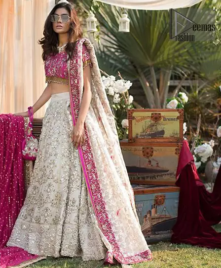 This dress is perfect for Reception or Nikah day. The bridal stands out due to its uniqueness and the perfect fusion of modern cut and traditional embroidery. Make your big day more interesting with this shabby chic statement intensified with rich zardosi work all over the front and bold patterns at daaman. The blouse is fully embellished with champagne and antique shaded embroidery all over and finishing with tassels. The outfit is beautifully coordinated with self printed dupatta adorned with shocking pink embellished applique on all four sides.
