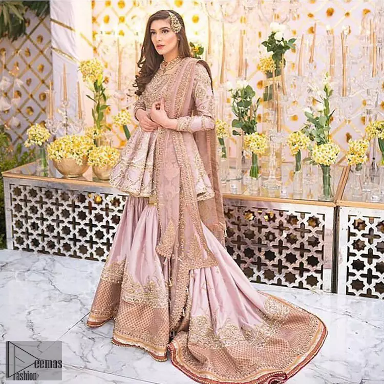 Brighten up your look with this outfit on your reception or nikah day. Wear this soft and supple hues richly decorated by shades of golden and silver with gota work motifs and geometric patterns at daaman. Having embellished bodice and full length sleeves adorned with geometric patterns and motifs. Style it up with artfully coordinated tea pink gharara finessed with floral motifs and gota work details at the bottom. Thin border on all four sides of the dupatta which have gold tila embroidery with sequins, beads and crystal touching.