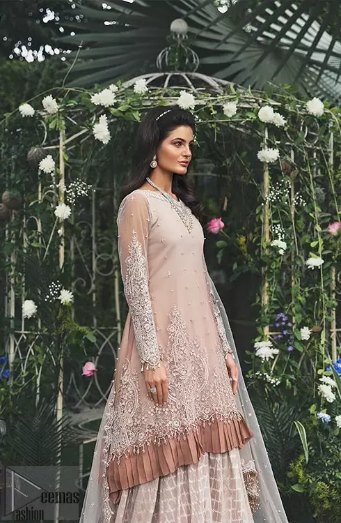 Go for this trendy dress which is perfect for your nikah. Feel glamorous in our ivory a-line frock with fascinating embellishment on neckline with silver kora, dabka, pearl and sequins. The daman is emphasized with detailed matching embellishment and finished with choclate brown frill. It comprises with sharara adorned with criss cross pattern. This outfit is paired up with net dupatta focusing on kora and dabka handwork borders on all four sides, sequins spray all over and finished with tassels.