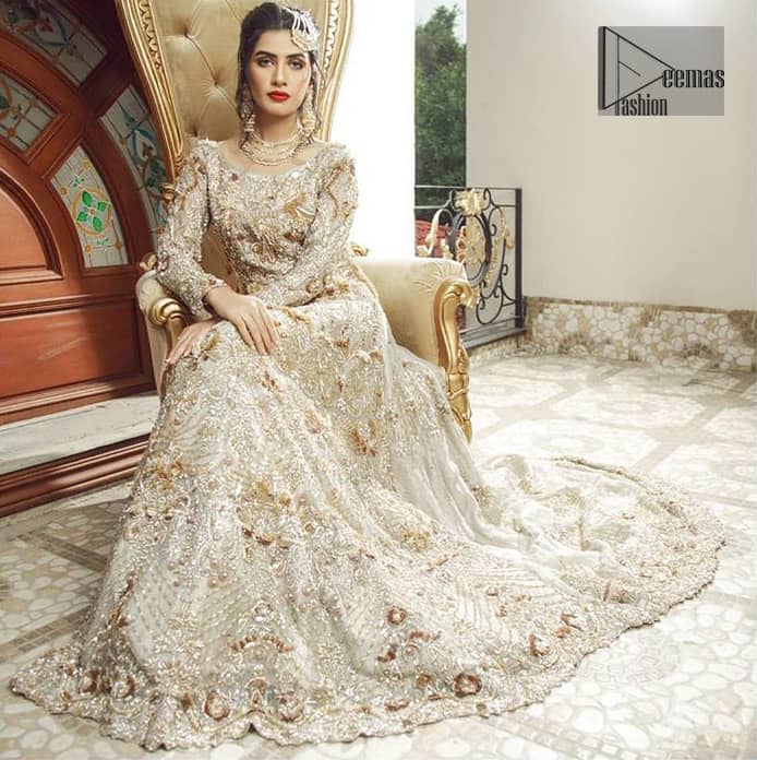 Bring out your beauty with this back trail maxi perfect for your big day. This bridal dress is beautifully sculptured with floral embroidery, adorned with cutwork borders embellished with silver kora, dabka, pearl and sequins work all over. The detailed resham and tilla work on the back of maxi and multiple floral motifs ornamented with gold kora and dabka embroidery on the bodice, the thick borders and floral bunches refined the classical royal look. Furthermore full length sleeves heavily embellished with zardosi work. It comprises with churidar pajama.