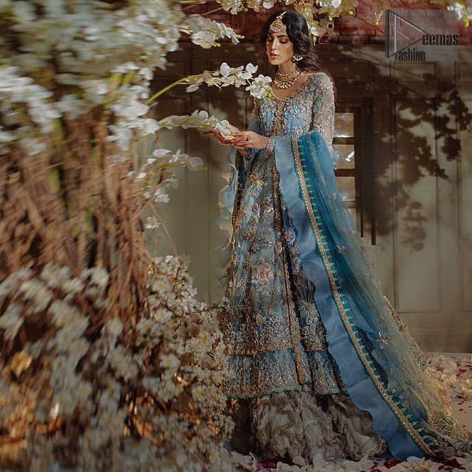 Reflecting royalty and the majestic beauty of statuesque shape and silhouette this dress is perfect for your walima and engagement function. Add some super cool twist to your look with this subtle colors in intricately embroidered frock. Capture the attention with fascinating embellishment on neckline with silver and dull golden kora, dabka, pearl and sequins. Having full length sleeves adorned with floral motifs. It comprises with ivory sharara. Thin border with floral motifs on all four sides of the dupatta which have gold tila embroidery with kora and dabka. 