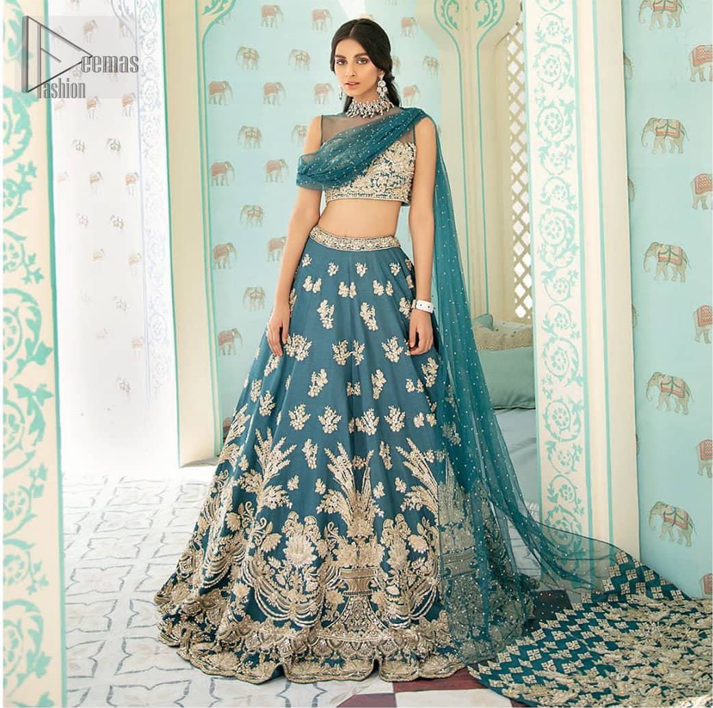 Captured in traditional silhouette. The bridal stands out due to its uniqueness and the perfect fusion of modern cut and traditional embroidery. It is highlighted with light golden kora, dabka, tilla, sequins and pearls. Blouse is enhanced with zardosi work. It comes with full embellished lehenga adorned with different size motifs and floral bunches. Style it up with net dupatta which is sprinkled with sequins all over it and embellished pallu to give it a perfect look.