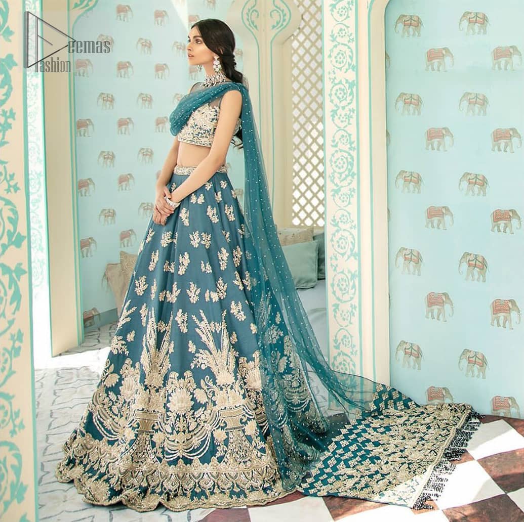 Captured in traditional silhouette. The bridal stands out due to its uniqueness and the perfect fusion of modern cut and traditional embroidery. It is highlighted with light golden kora, dabka, tilla, sequins and pearls. Blouse is enhanced with zardosi work. It comes with full embellished lehenga adorned with different size motifs and floral bunches. Style it up with net dupatta which is sprinkled with sequins all over it and embellished pallu to give it a perfect look.