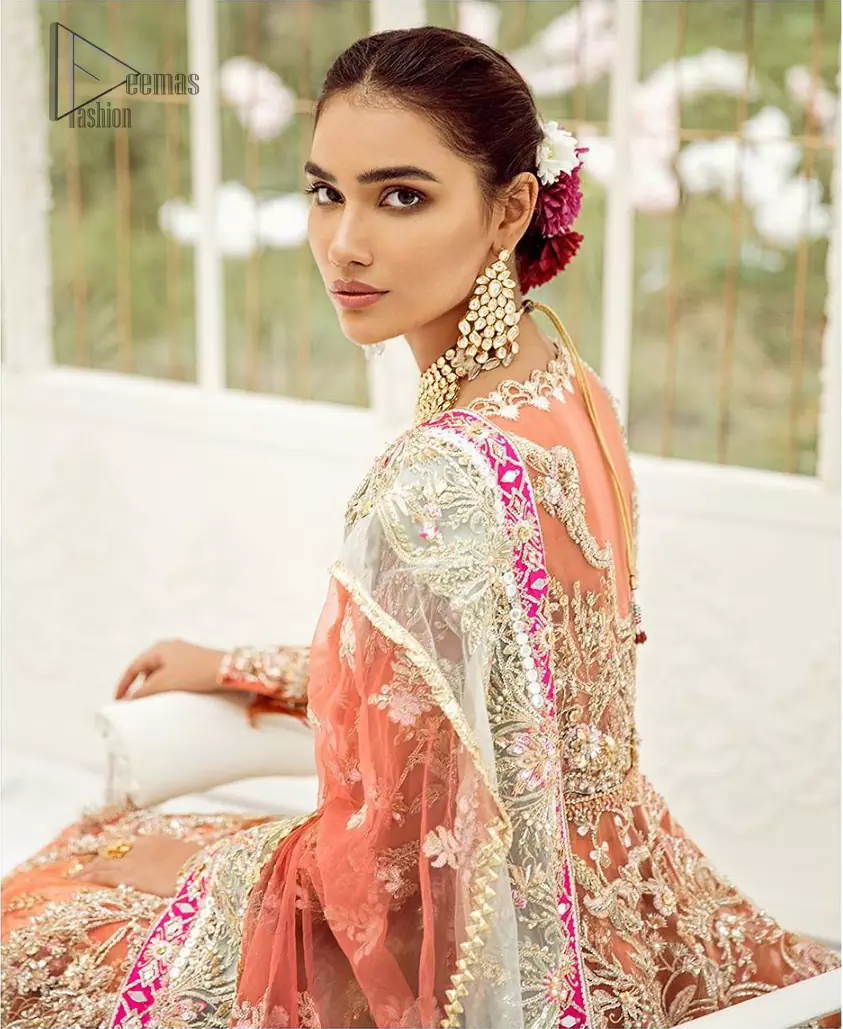 Captured in traditional silhouette, The bridal stands out due to its uniqueness and the perfect fusion of modern cut and traditional embroidery. This front open short frock is highlighted with kora, dabka, tilla, sequins and pearls. It comes with full embellished lehenga adorned with floral bunches, applique on the hemline and sequins spray all over it. It is coordinated with organza dupatta which is sprinkled with tiny floral motifs all over and a thick embellished border on all four sides with applique details.
