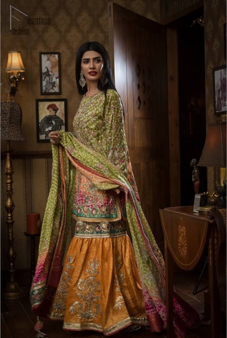 Brighten up your look with this beautiful mehndi dress comes with a beautiful parrot green shirt. This shirt is adorned with light gold kora, dabka, tilla and sequins work, furthermore the hemline is enhanced with applique embellishment. Paired it up with traditional jamawar gharara ornamented with zardozi work and finished with lace embellished border. It is coordinated with parrot green dupatta dyed from pallu in two colors and adorned with applique embellished border.