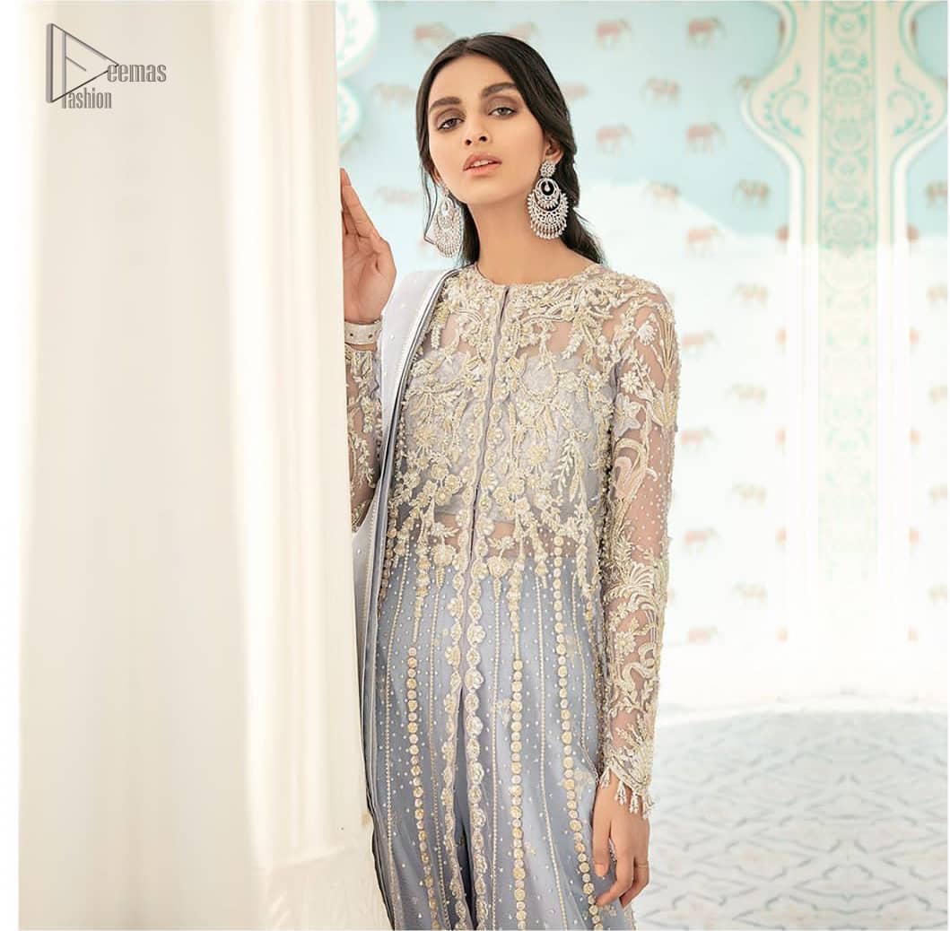 You are all set to make a lasting impact with the divine royalty of this dress. This artisan piece includes intricate hand-embellishment. This technique gives this garments a unique look, and helps to sustain a traditional craft carried out by skilled artisans. This multiple panels front open maxi is ornamented by light gold zardozi work with beautiful embellished motifs around the hem and vertically worked gold lines. It comprises with raw silk sharara adorned with tiny floral motifs and dupatta is decorated with sequins spray all over.